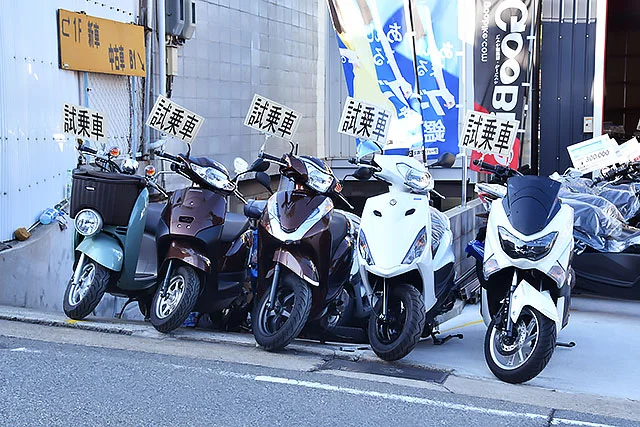 販売店の前に置かれた試乗用スクーターを横から見た様子